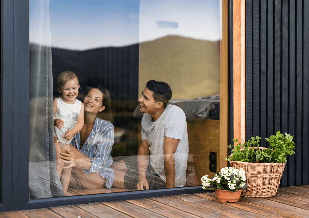 Family looking out the window of their new home