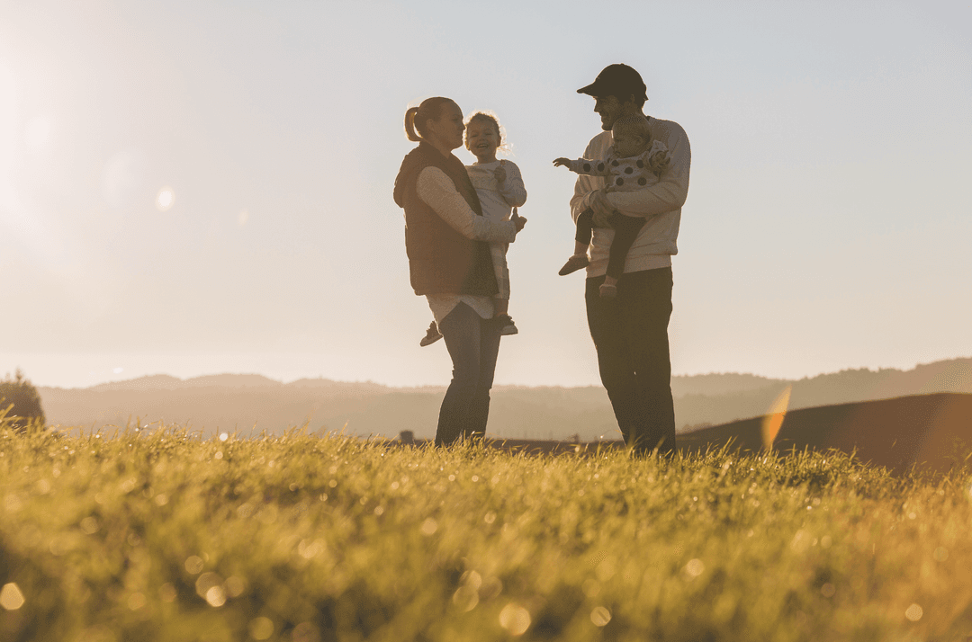 Family silhouette walking together at sunset